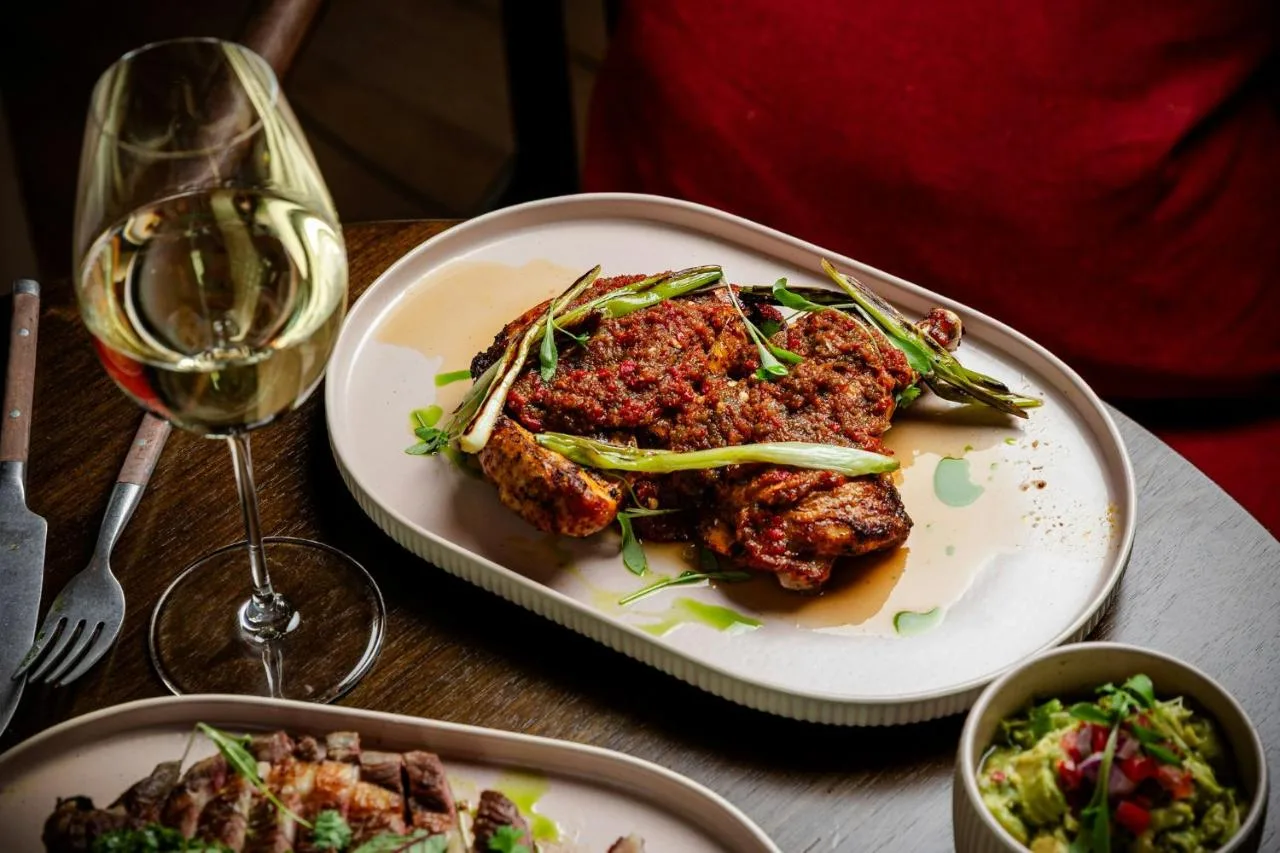 Table with plate of food and wine at The Social Hub Glasgow